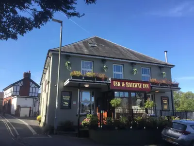 a building with a sign that reads new return inn at Usk And Railway Inn in Sennybridge