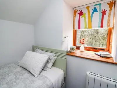 a bedroom with a bed and a window at Ty Hir at Blaenbrynich Farm in Brecon