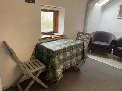 a room with a table and a chair and a window at Ty Hir at Blaenbrynich Farm in Brecon