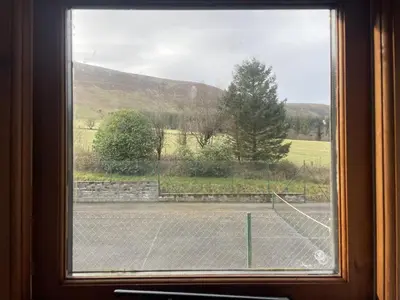 a window with a view of a tennis court at Ty Hir at Blaenbrynich Farm in Brecon