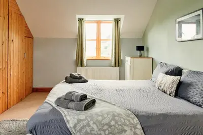 a bedroom with two beds and a window at Finest Retreats - The Welsh Farmhouse in Aberystwyth