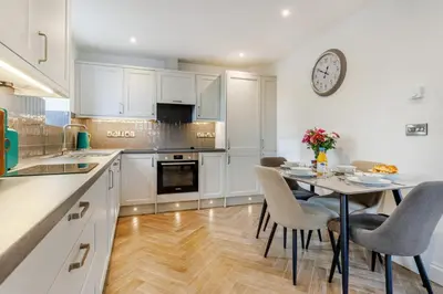 a kitchen with a table and a clock on the wall at 2 Bed in Capel Bangor oc-m30146 in Capel Bangor
