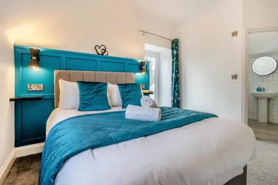 a large bed with a blue headboard in a bedroom at 2 Bed in Capel Bangor oc-m30146 in Capel Bangor