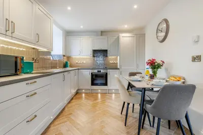 a kitchen with white cabinets and a table and chairs at 2 Bed in Capel Bangor oc-m30146 in Capel Bangor