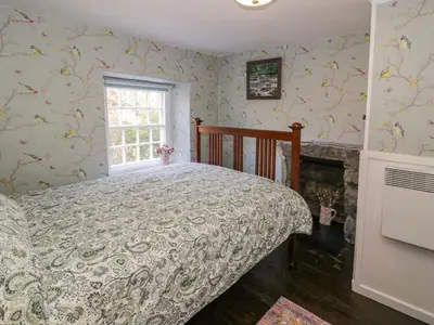 a bedroom with a bed and a window at River Cottage in Llanbedr