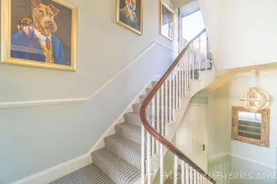 a staircase with a painting of a dog on the wall at Seafront House in Aberdyfi