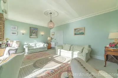 a living room with a couch and a table at Seafront House in Aberdyfi