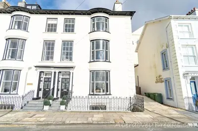 a white house with black windows at Seafront House in Aberdyfi