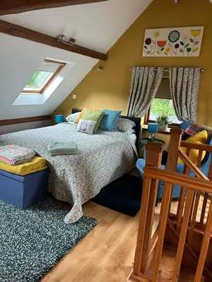 a bedroom with a large bed and a staircase at Cosy riverside property in Aber-Brân