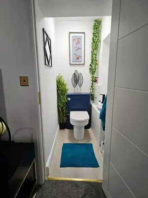 a bathroom with a toilet and a blue rug at Bryn Aber-The House on the Hill in Llangollen