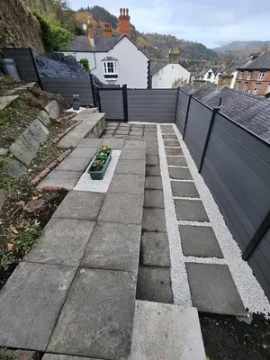 a backyard with a stone walkway with a fence at Bryn Aber-The House on the Hill in Llangollen