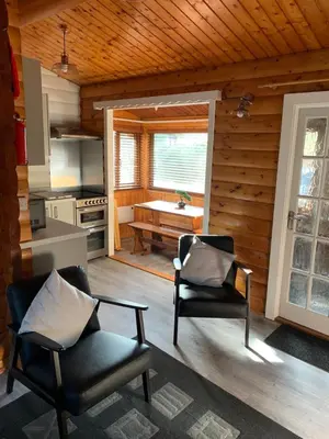 a living room with two chairs and a kitchen at Fernleys Place in Trawsfynydd