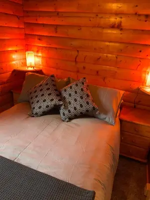 a bedroom with a bed in a wooden wall at Fernleys Place in Trawsfynydd
