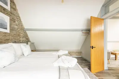 a bedroom with a bed with white sheets and pillows at The Royal Oak, Gladestry in Gladestry