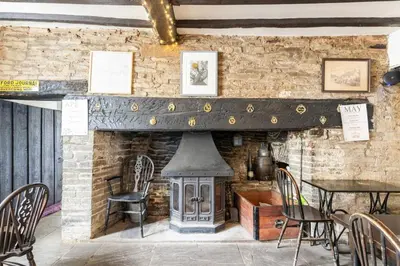 a fireplace in a restaurant with a table and chairs at The Royal Oak, Gladestry in Gladestry