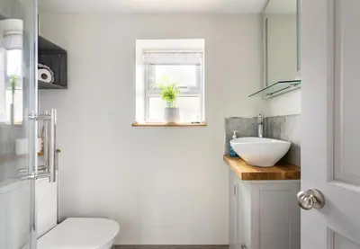 a bathroom with a toilet and a sink and a window at The Royal Oak, Gladestry in Gladestry