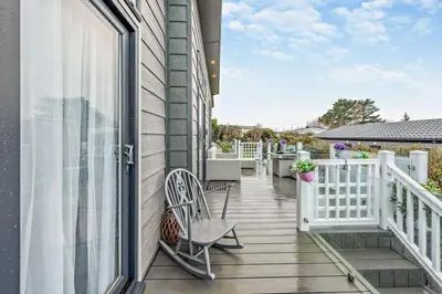 a balcony with two chairs and a window at Coogee View Lodge in New Quay