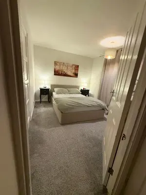 a bedroom with a bed and two tables and two lamps at Meole Brace room in Meole Brace