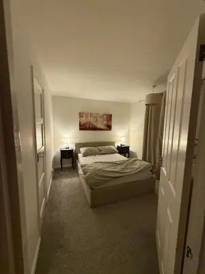 a bedroom with a bed and two end tables with lamps at Meole Brace room in Meole Brace