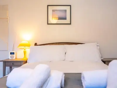 a bedroom with a bed and a table with a lamp at Cosy cottage hideaway set in beautiful countryside - Pass the Keys in Hopesay