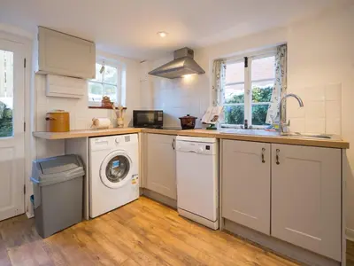 a kitchen with a washing machine and a washer at Cosy cottage hideaway set in beautiful countryside - Pass the Keys in Hopesay