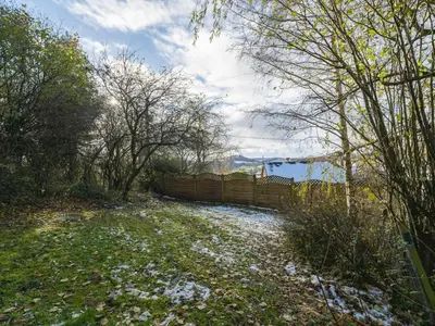 a snow covered yard with a fence and trees at Cosy cottage hideaway set in beautiful countryside - Pass the Keys in Hopesay