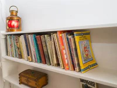 a shelf filled with books and a lamp at Cosy cottage hideaway set in beautiful countryside - Pass the Keys in Hopesay