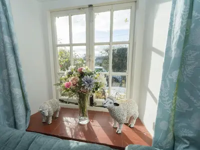 two stuffed animals standing on a table next to a window at Cosy cottage hideaway set in beautiful countryside - Pass the Keys in Hopesay