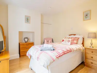 a bedroom with a bed and a dresser and a tv at Court House in Hay-on-Wye