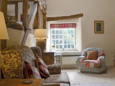 a living room with two chairs and a window at The Bothy-E2934 in Clun