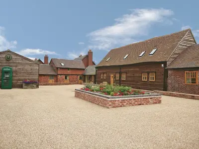 a group of buildings with flowers in a courtyard at The Olde Granary - E4298 in Halston
