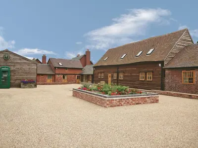 a group of buildings with flowers in a courtyard at Shippon Cottage - E4299A in Halston