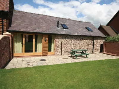 a picnic table in front of a stone building at Piglets Place - E4300 in Halston