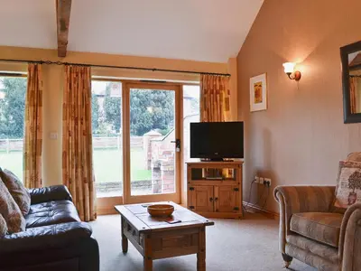 a living room with a tv and a couch and a table at Piglets Place - E4300 in Halston