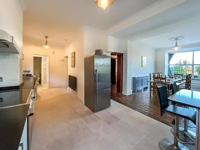 a kitchen and dining room with a stainless steel refrigerator at Glannant - 5 Bed & 4 Bathroom - Fairbourne, Barmouth, Mawddach Estuary in Arthog