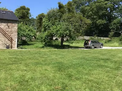 a car parked next to a tree in a field at Ashford Bridge Barn in Ludlow