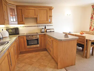 a kitchen with wooden cabinets and a counter top at Rhiwgoch - Hw7449 in Harlech