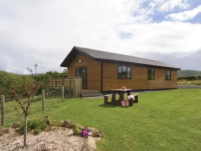 a log cabin with a picnic table in the yard at Ithon Bank - Hw7478 in Penybont