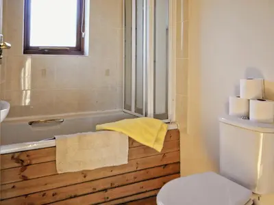a bathroom with a tub and a toilet and a yellow towel at Ithon Bank - Hw7478 in Penybont