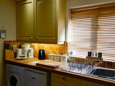a kitchen counter with a sink and a dishwasher at Morlais - Hw7599 in Llanaber
