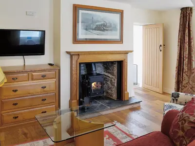 a living room with a fireplace and a tv at Porter's Lodge in Glyn-Dyfrdwy