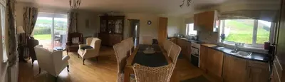 a kitchen with a table and chairs in a room at Aberceiro Bungalow in Aberystwyth