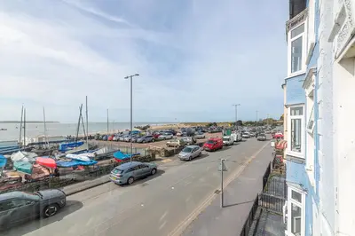 a busy street with cars parked in a parking lot at Popular Sea View Apartment in Aberdyfi
