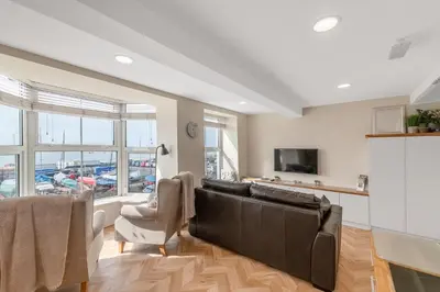 a living room with a couch and a tv at Popular Sea View Apartment in Aberdyfi