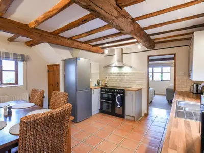 a kitchen with a table and a refrigerator at Uk46590 - Longmynd in Church Stretton