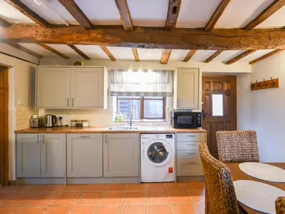 a kitchen with a washing machine and a table at Uk46590 - Longmynd in Church Stretton