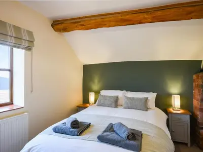 a bedroom with a large bed with towels on it at Uk46590 - Longmynd in Church Stretton