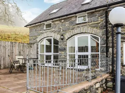 a stone cottage with a patio and a table at Hirnant - Uk48512 in Bala