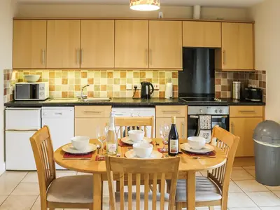 a kitchen with a wooden table with chairs and a dining room at Berwyn - Uk48507 in Bala