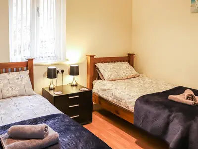 a bedroom with two beds and a table with two lamps at Berwyn - Uk48507 in Bala
